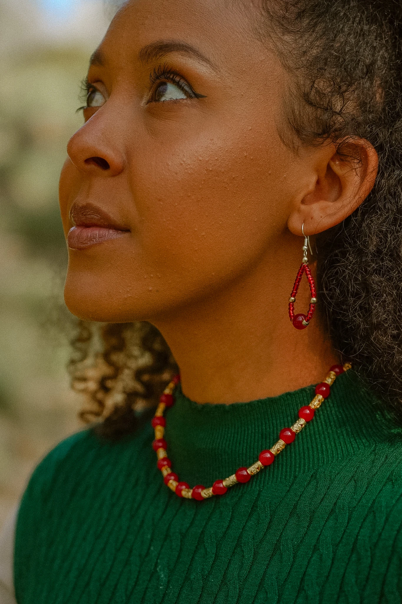 Wildflower Spell portrait with red beaded jewellery and green knit styling by Lunar Lens Creative Agency