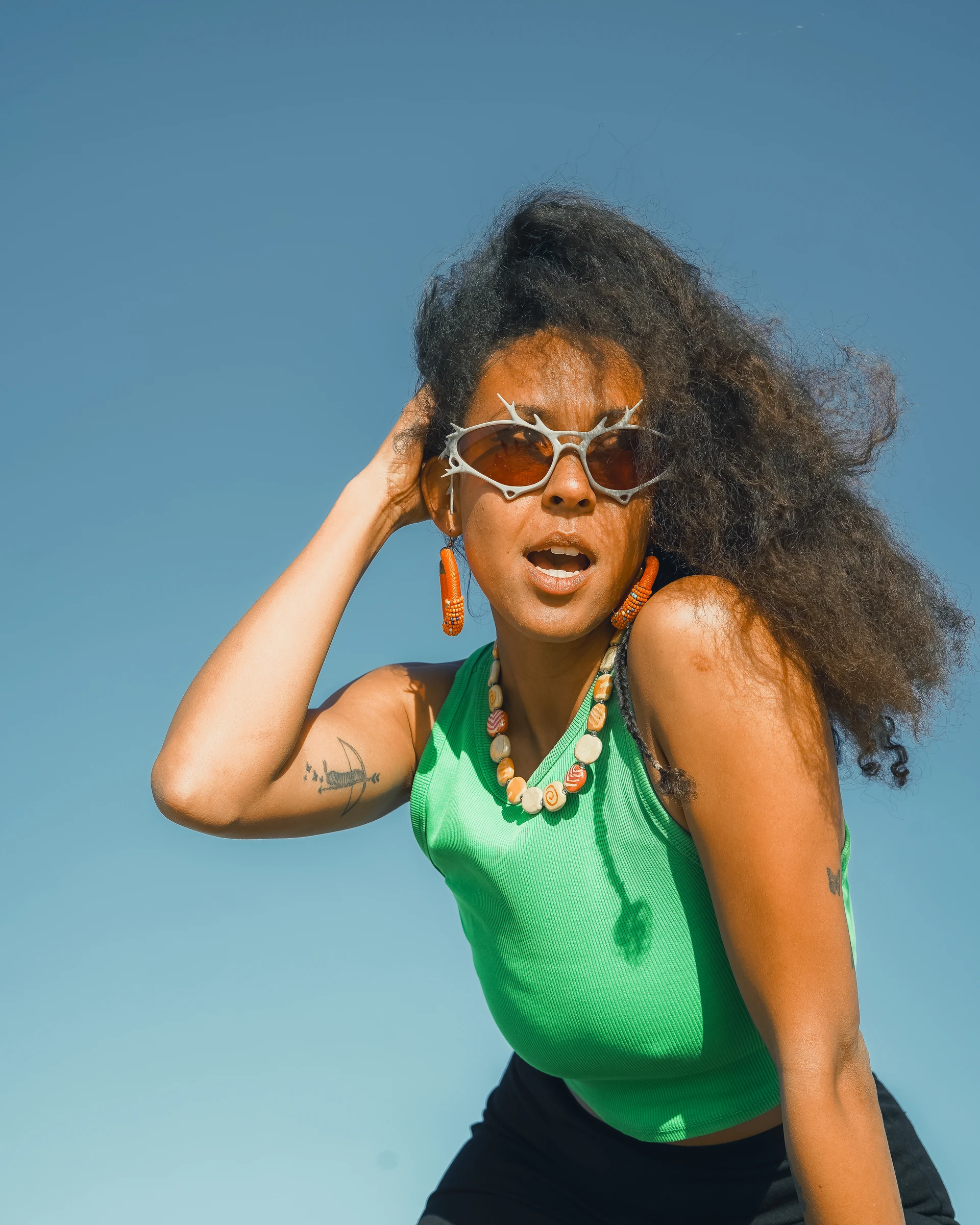 ITURA Studio eyewear portrait of a model in green against blue sky by Lunar Lens Creative Agency