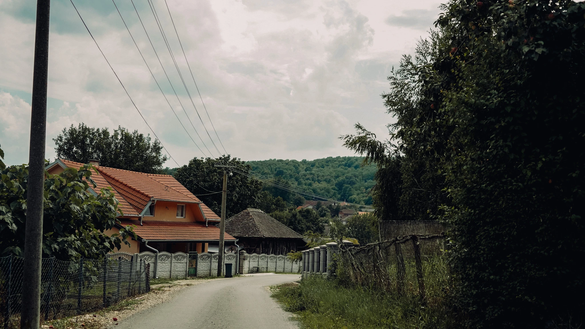 Remains of Peaceful Life Serbian village road and hillside homes by Lunar Lens Creative Agency