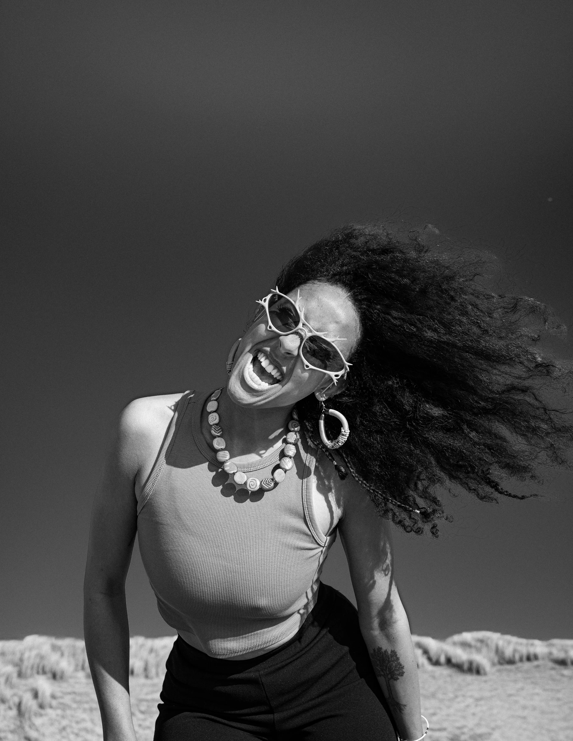Black-and-white sunglasses campaign portrait on the beach by Lunar Lens Creative Agency