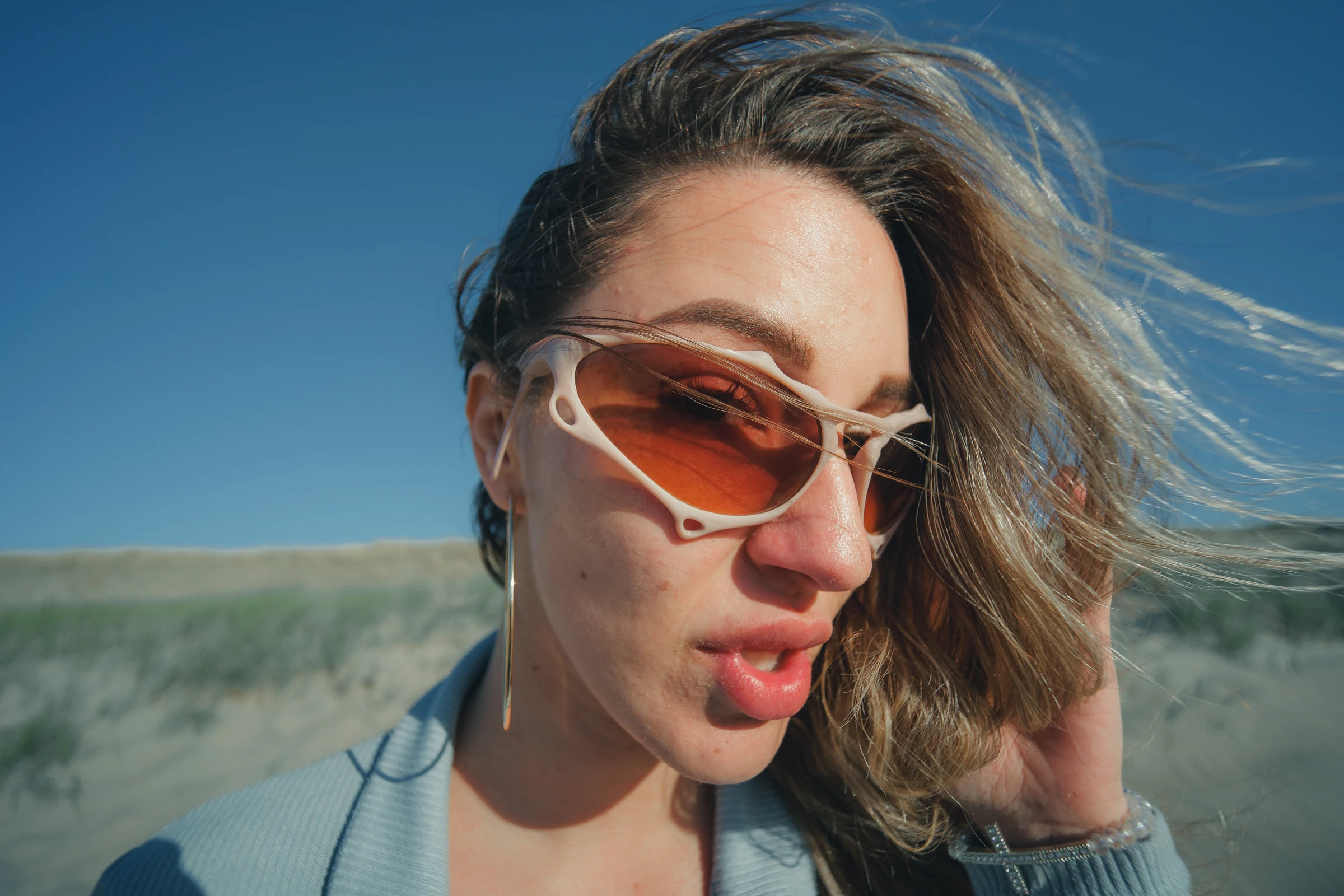 ITURA Studio close-up of orange lens sunglasses in the dunes by Lunar Lens Creative Agency