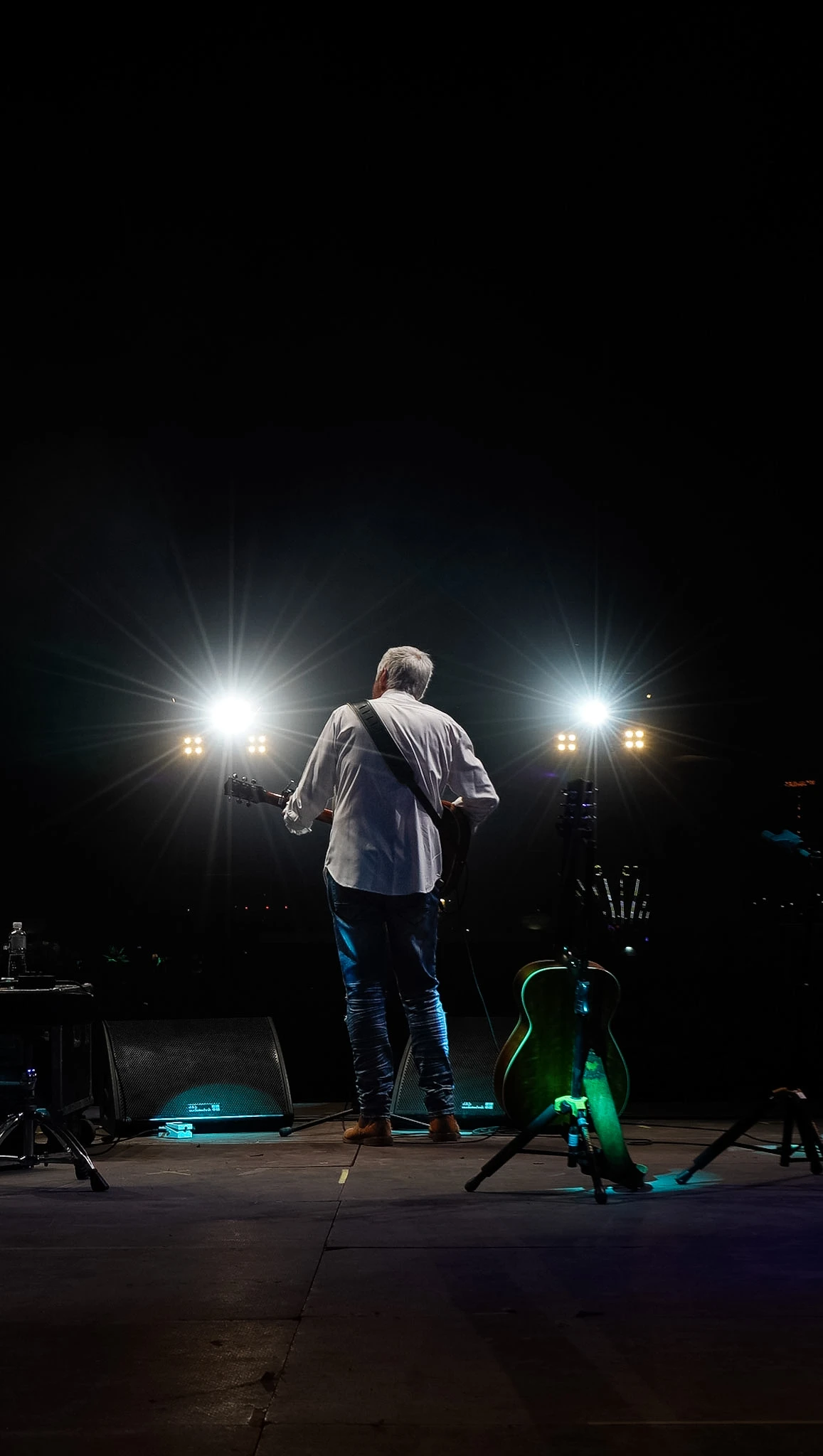 Guitar Art Festival guitarist seen from behind under stage spotlights by Lunar Lens Creative Agency