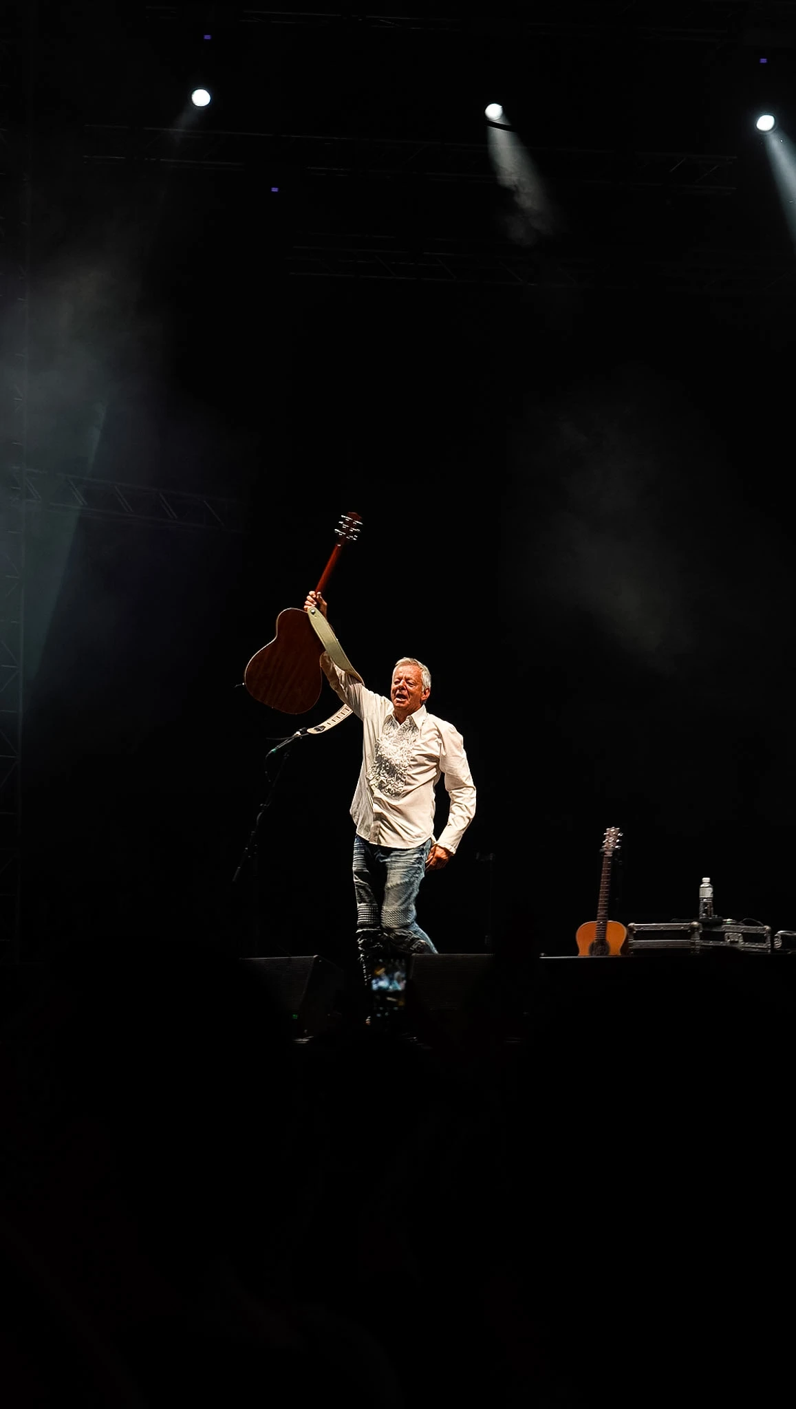 Guitar Art Festival performer raising a guitar on stage by Lunar Lens Creative Agency